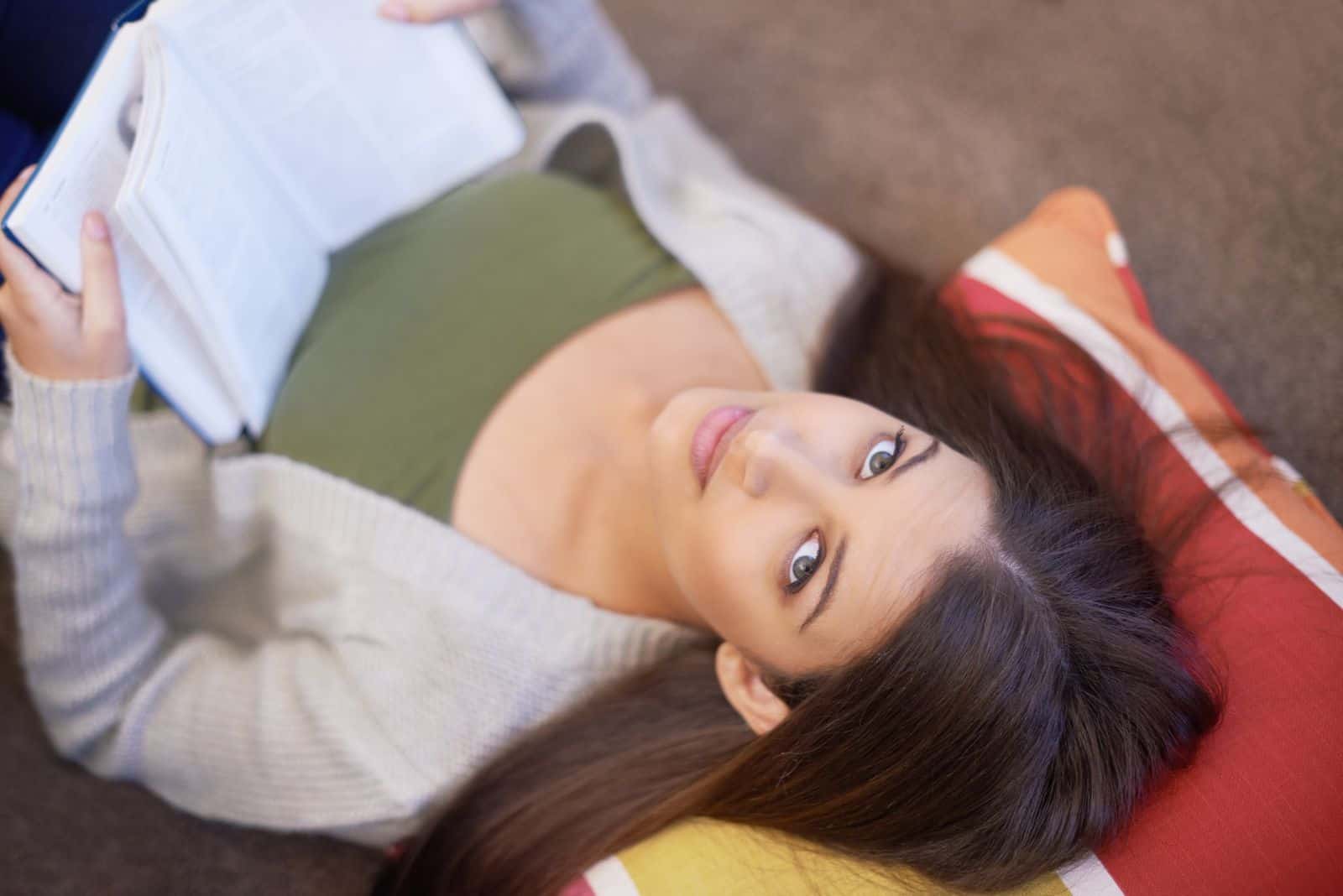 49682410 reading an interesting article a young woman reading a book at home